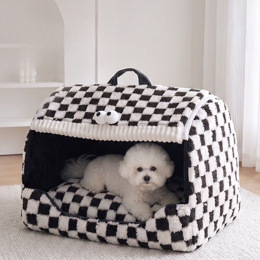 Small white dog resting in the black and white checkerboard pet house