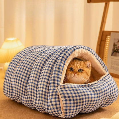 Cat resting in blue plaid sleeping bag bed