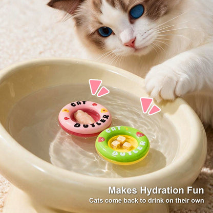 Pink and green floating swim rings in a cat water bowl