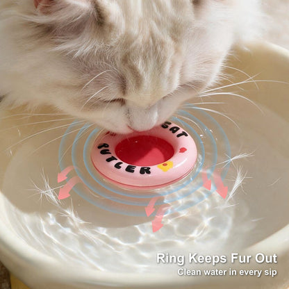 Cat drinking from a pink floating water ring