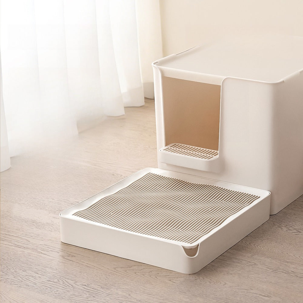 Rigid litter trapping platform in front of a cream cat litter box