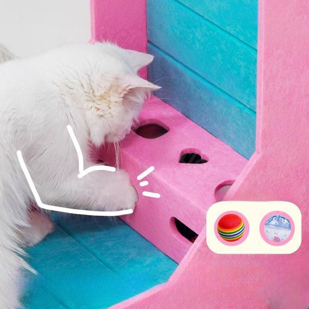 Cat pawing at the bell balls hidden in the peek-a-boo toy box