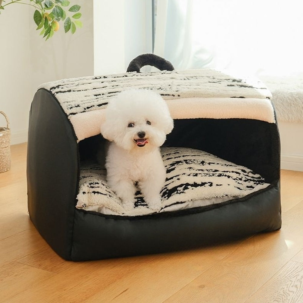 Small white dog in black plush pet house