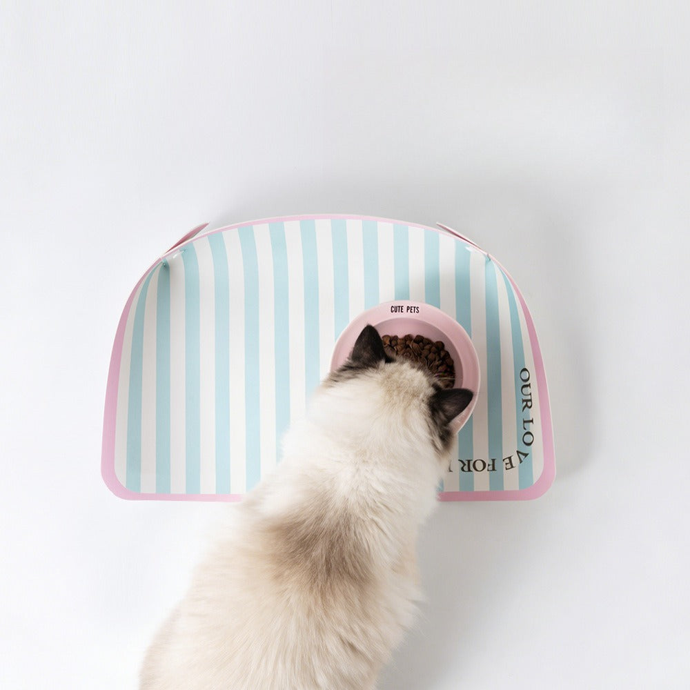 Ragdoll cat eating on a mint striped waterproof feeding mat