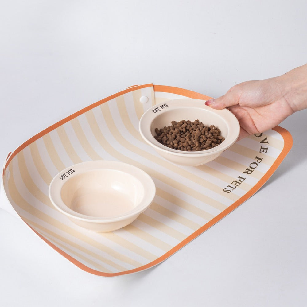Two pet bowls on a feeding mat with snap-up corners